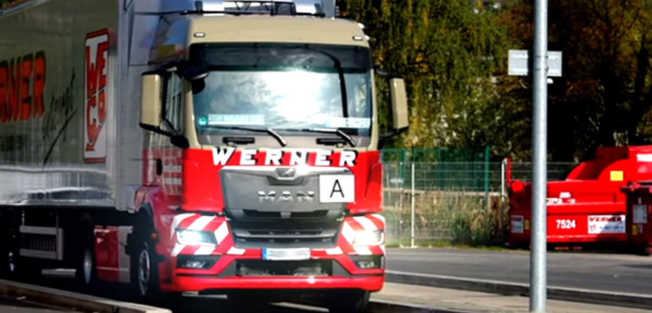 LKW der gewerblichen Abfallentsorgung in Bayern beim Abholen eines Containers